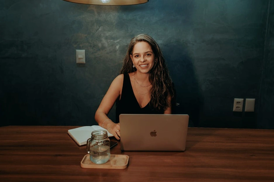 Uśmiechnięty profesjonalista pracujący na laptopie w jasnym biurze.